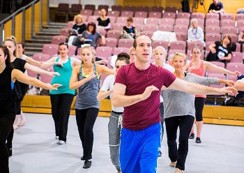 Image of a choreographer working with performers in rehearsal.