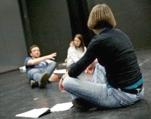 Photo of a director working with two actors.