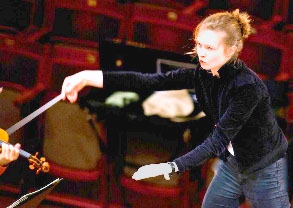 Photo of a music director working with the orchestra.