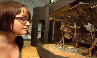 Photo of Set Designer looking at a 3-D model of the design for a production.