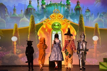 Photo of a stage production of "The Wizard of Oz" with projected background